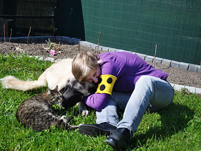 Blindes Mädchen spielt mit Hund und Katze